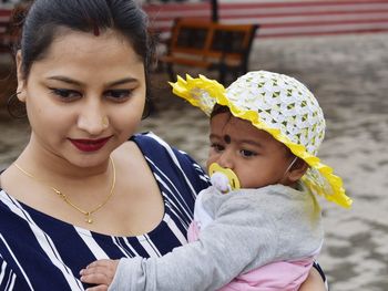 Close-up of mother carrying daughter outdoors