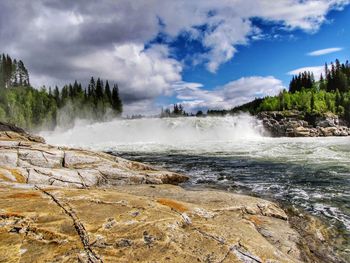 Scenic view of waterfall against sky