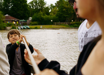 Boy pulling a raft with a rope across the lake