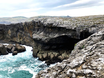 Rock formations in sea against sky