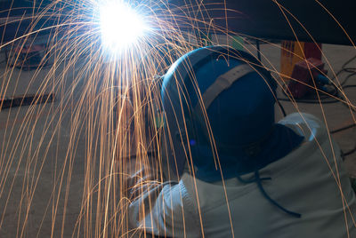 High angle rear view of man welding at workshop