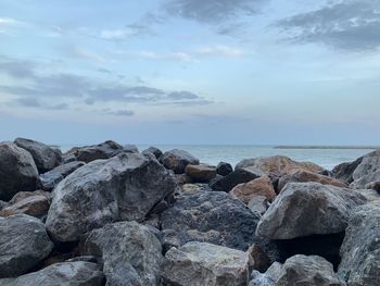 Rocks by sea against sky