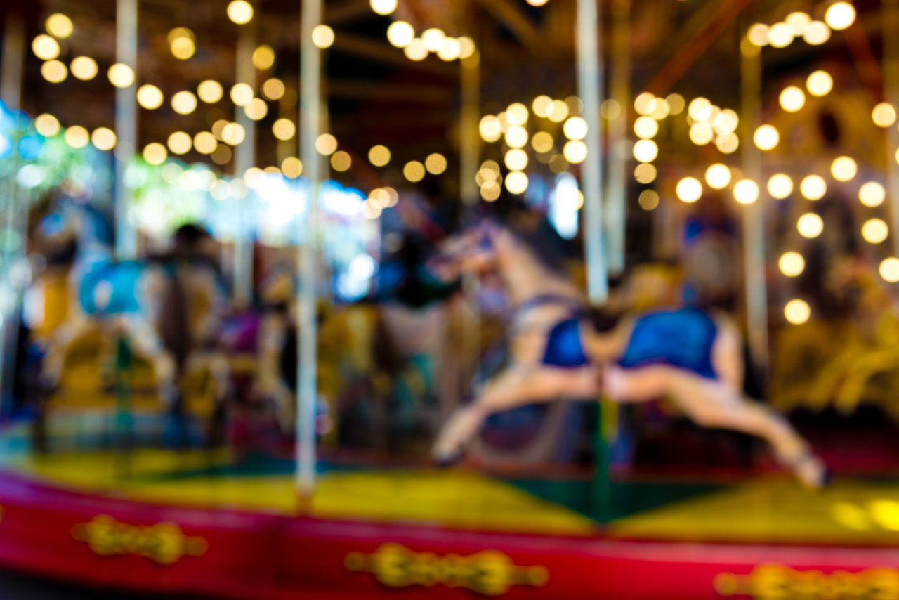 PEOPLE AT ILLUMINATED AMUSEMENT PARK