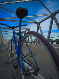 Bicycle by sea against blue sky