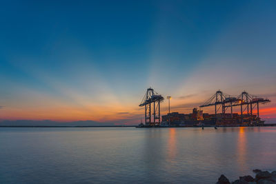 Pier over sea against sky during sunset