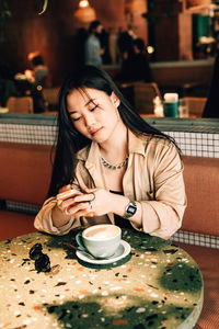 Young woman drinking coffee cup on table