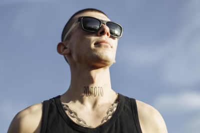 Close-up portrait of young man with blue sky background