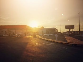 Cars on road against sky during sunset