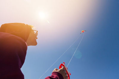 Low angle view of person flying kite against clear sky