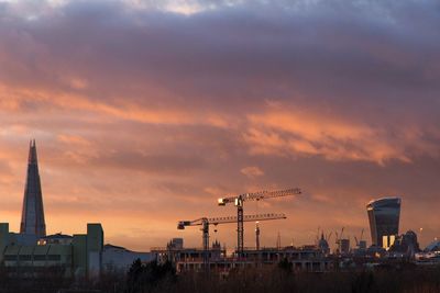 Cityscape against cloudy sky during sunset