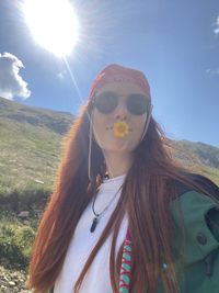 Portrait of young woman in sunglasses against sky