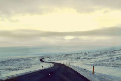 Road by landscape against sky