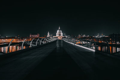 Illuminated bridge against sky at night