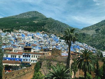 High angle view of townscape by mountains against sky