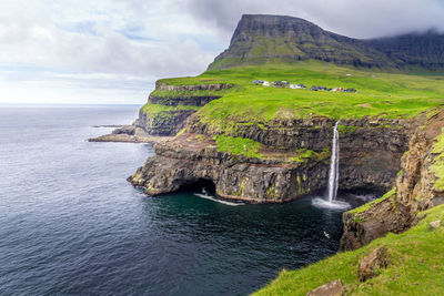 Scenic view of waterfall falling into the sea