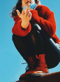 Midsection of woman standing against orange blue sky