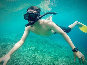 Portrait of shirtless man swimming in sea