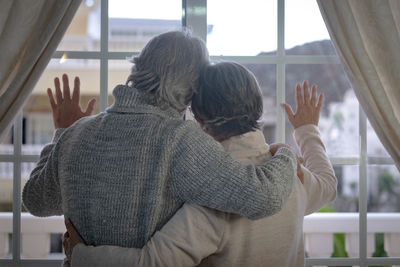 Rear view of couple kissing in the window