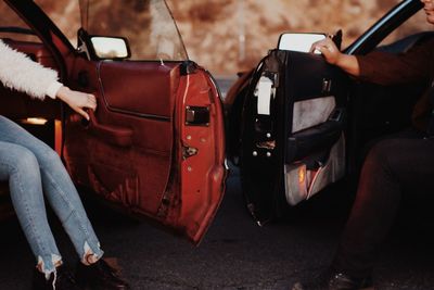 Low section of man and woman in cars on road