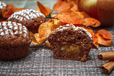 Chocolate muffins with apple filling on a background of autumn leaves and cinnamon