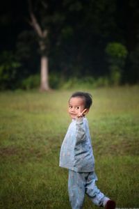 A 3-year-old boy, posing with peace regards