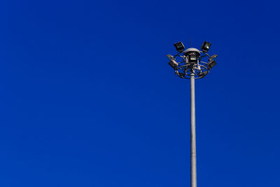 Low angle view of floodlight against blue sky