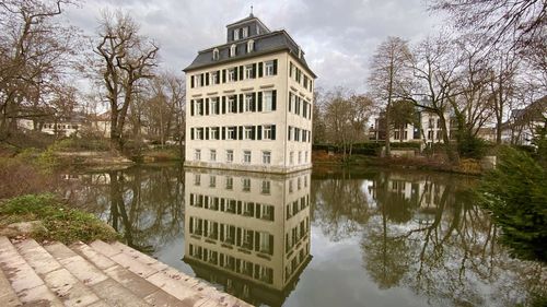 Reflection of building in lake against sky
