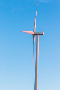 Low angle view of windmill against clear blue sky