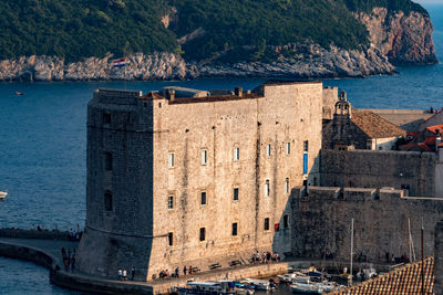Old ruins by sea against sky