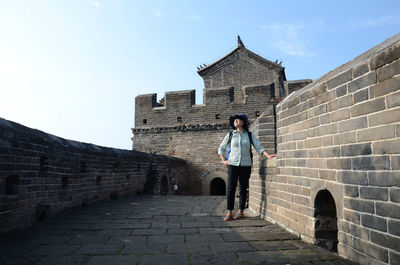 Woman standing on brick wall