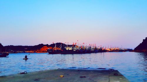 Scenic view of river against clear sky at sunset