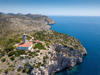 Scenic view of sea by buildings against sky