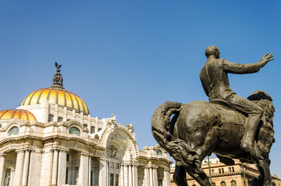 Low angle view of statue against clear blue sky