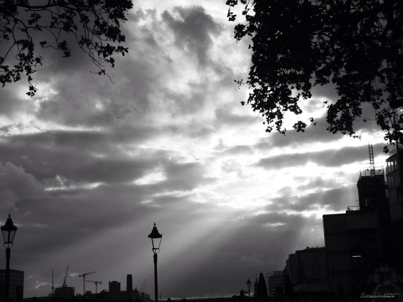 sky, cloud - sky, cloudy, low angle view, building exterior, silhouette, built structure, cloud, street light, architecture, weather, overcast, storm cloud, dusk, tree, city, nature, outdoors, no people, dramatic sky