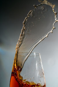 Close-up of glass bottle against water