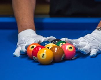 Midsection of man arranging pool balls on table