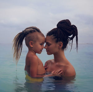 Boy and son in water against sky