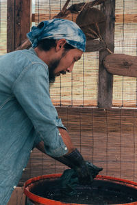 Side view of a man working on wood