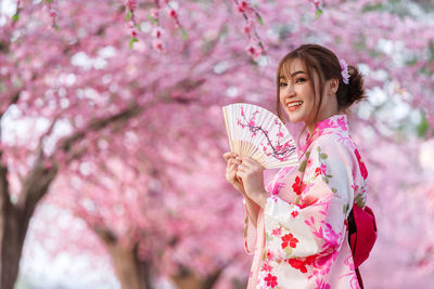 Portrait of woman with pink cherry blossom