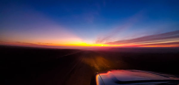 Scenic view of sunset seen through car windshield