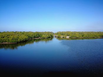 Scenic view of lake against clear blue sky