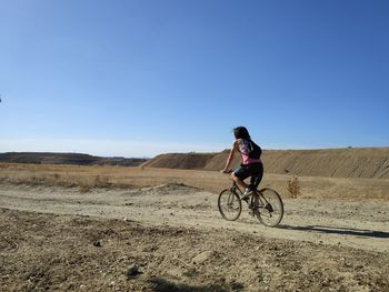 Man riding motorcycle on land against sky