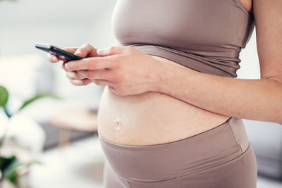 Midsection of woman using mobile phone