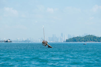 Man in sea against sky