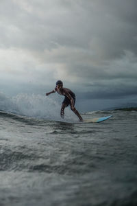 Man surfing in sea against sky