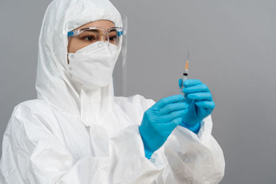 Female doctor holding syringe against white background