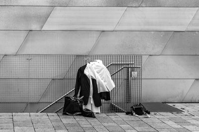 Official ceremonial clothing hangs on the railing in front of the façade of a modern building