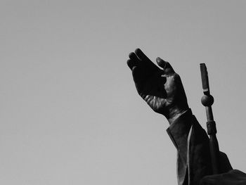 Low angle view of hand against clear sky