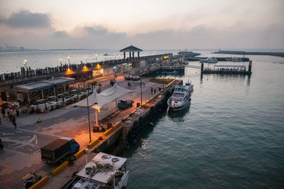 High angle view of boats moored at harbor during sunset