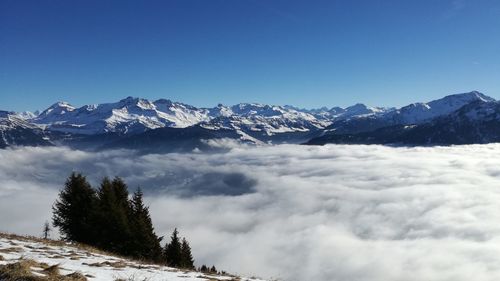 Scenic view of snowcapped mountains against blue sky